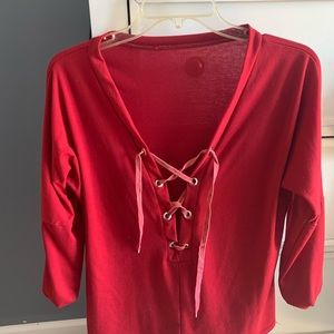 Low cut, lace up red shirt.